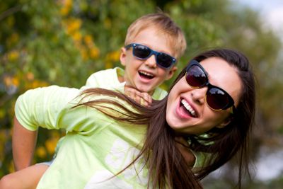 Little boy and mother walking in autumn park