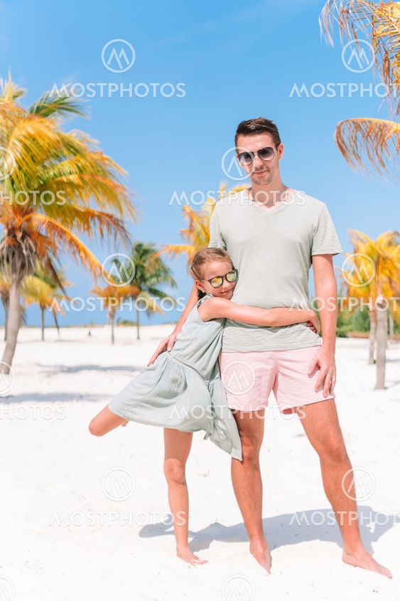 Father and little girls have a lot of fun on white sandy...