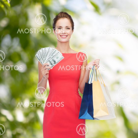 smiling elegant woman in dress with shopping bags