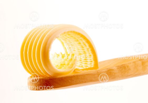 Butter curl on a wooden spoon
