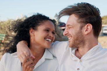 Happy, interracial couple and laughing together outdoor...