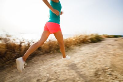 Young woman on her evening jog along the seacoast (motion...