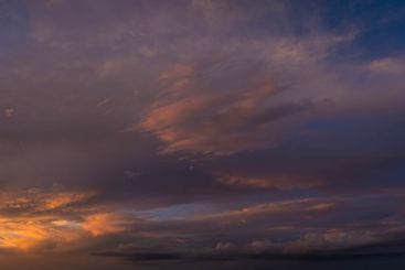 Dramatic sunset sky covered with colorful yellow clouds....