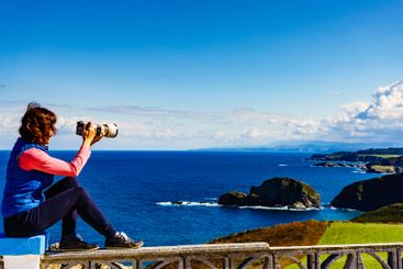 Tourist with camera on Asturias coast, Spain