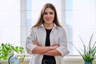 Portrait of young confident smiling woman in home interior