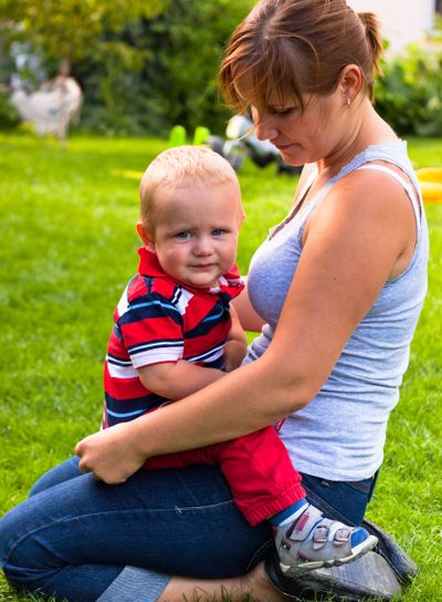 Woman and toddler sitting in the grass