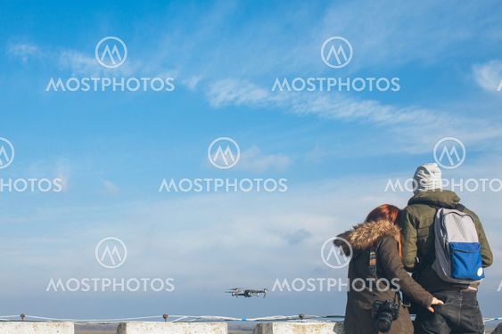 Two couple taking a selfie with a drone, drone navigating