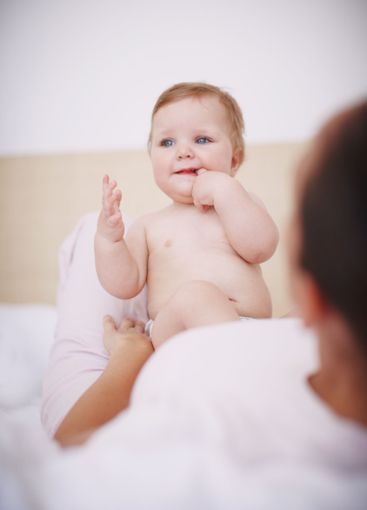 Baby, parent and teething with hands in home, love and...