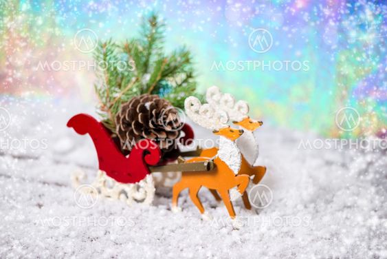 Christmas decoration reindeer and Santa sleigh with branch fir tree, pinecones in snow on north light background, closeup