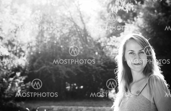 Smiling blond young woman in a park