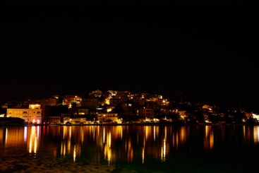 Night view of buildings in coastal town with with...