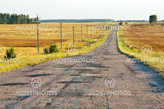 Rough paved road in a countryside in a sunny late afternoon