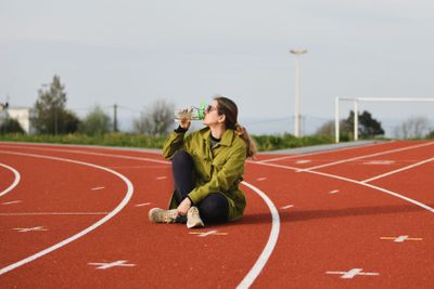 A woman drinking water at the stadium