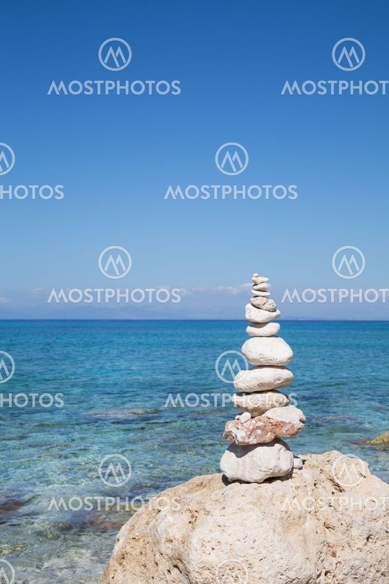 Blue ocean background with a pillar of stones for meditative or spiritual concepts