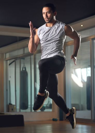 Fitness, jumping and health with man in gym for...