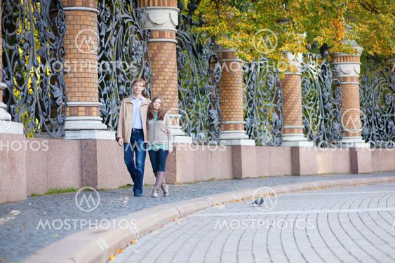 Couple walking by the beautiful grill of Mikhailovsky (Michael) garden of Saint-Petersburg