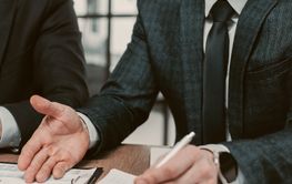 A man is pointing at a tablet with a graph on it