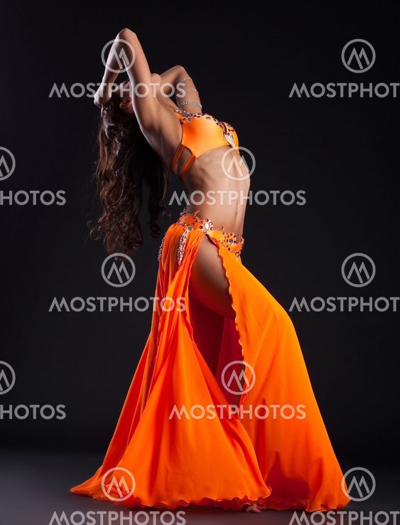 Expressive woman posing in orange arabic costume