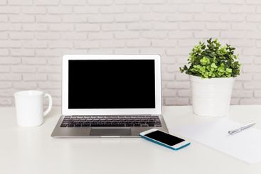 Workspace arrangement with a laptop, smartphone, coffee...