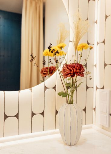 Close-up of a ceramic vase with flowers on a marble...