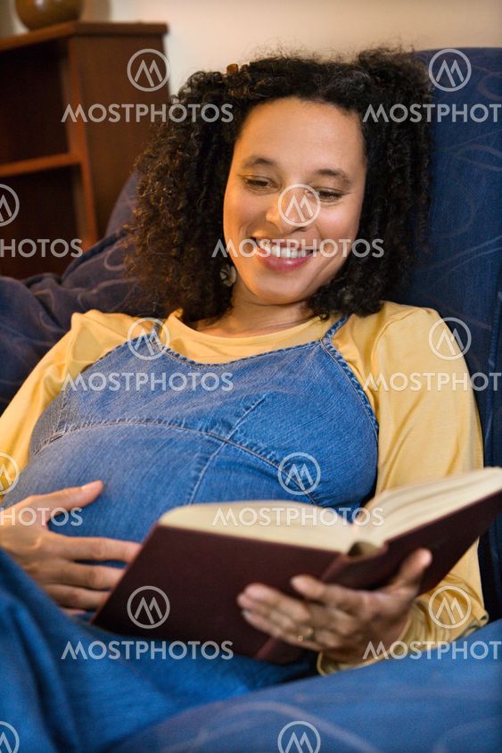 Pregnant woman reading book.