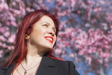 Woman with cherry flowers surrounded by blossoming trees...