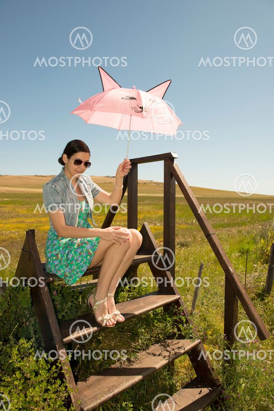 Beautiful adult smelling flowers on sunny field enjoying herself