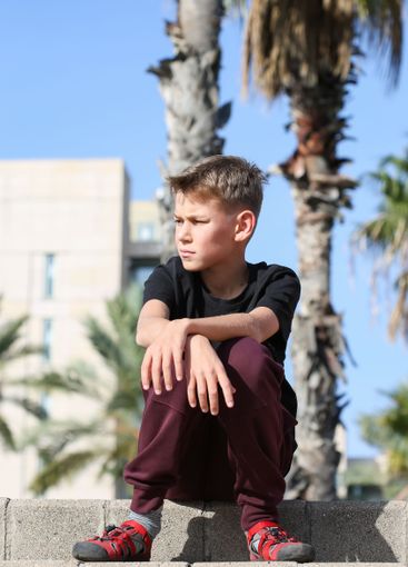 Handsome teenager standing with skateboard. Adolescent...