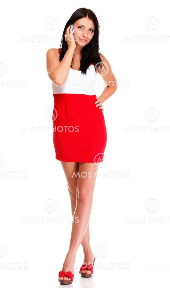 Full length of woman walking talking on mobile phone...
