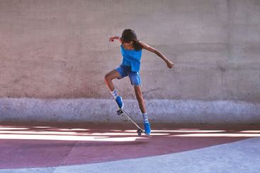 Skateboard, city and girl with trick in air for jump...