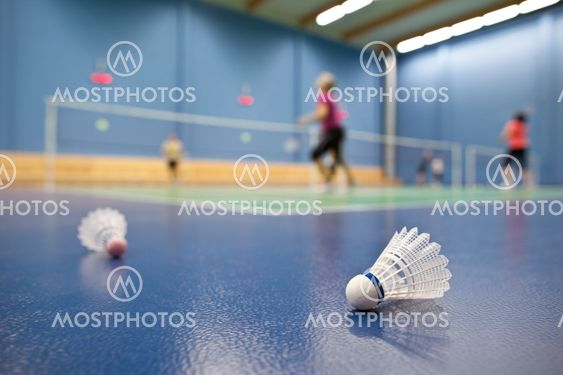 badminton - badminton courts with players competing; shuttlecocks in the foreground (shallow DOF; color toned image)