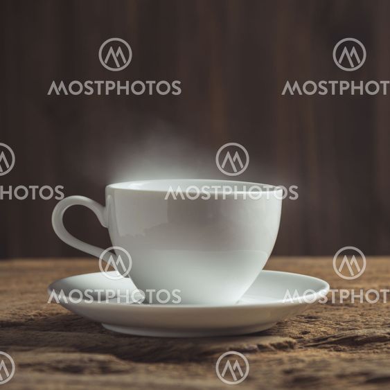 white coffee cup with smoke on wood table