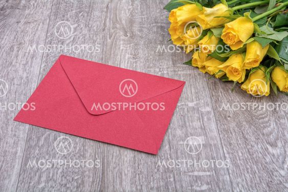 Red envelope and roses on a wooden background