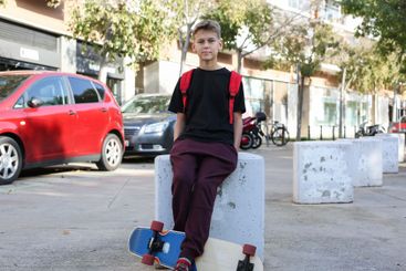 Handsome teenager standing with skateboard. Adolescent...