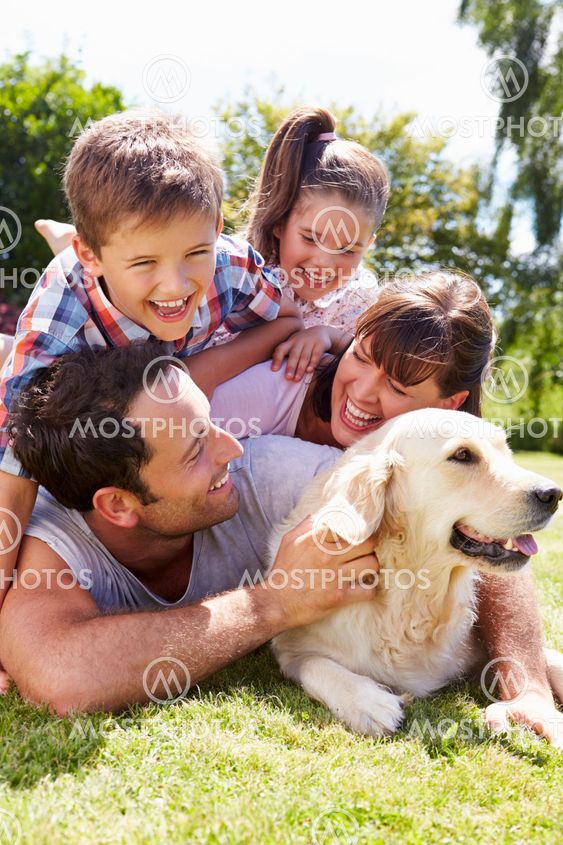 Family Relaxing In Garden With Pet Dog