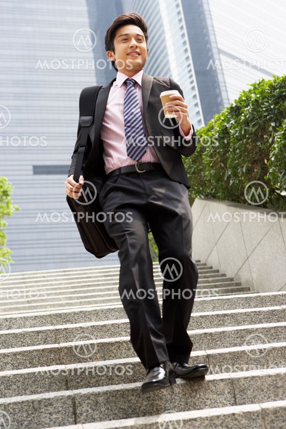 Chinese Businessman Rushing Down Steps Carrying Bag And Takeaway Coffee