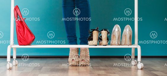 Woman choosing shoes to wear in mall or wardrobe