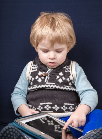 Little toddler boy playing with tablet pc