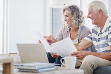 Happy, senior couple and documents with laptop for...