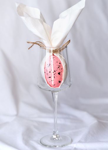 Decorative rabbit made from egg and napkin in wineglass....