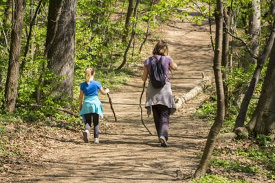 Mother and daughter walking in spring forest