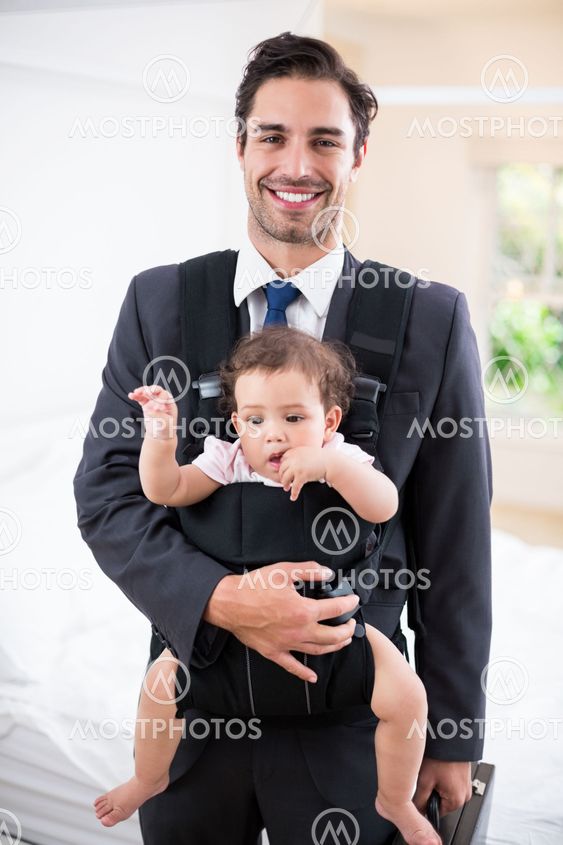 Portrait of smiling father carrying baby