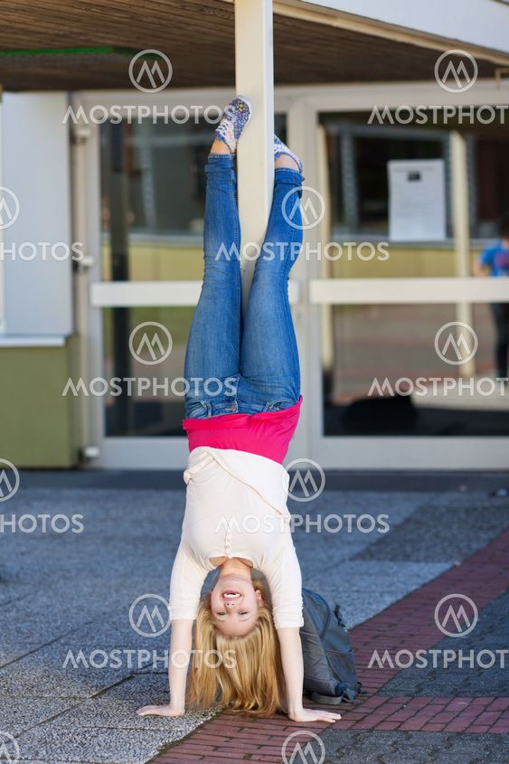 Teenage girl doing handstands at school