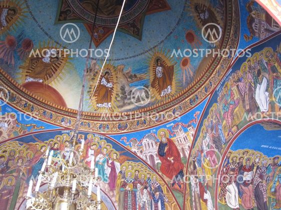 Close-up view of a painted vault in a romanian orthodox monastery with religious colored frescoes