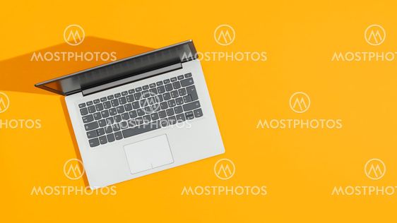 Laptop on a bright yellow desk