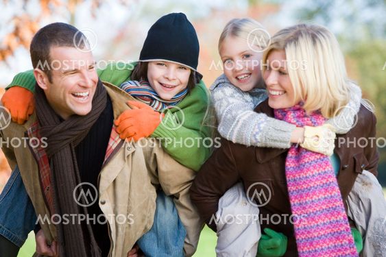 Parents giving children piggyback ride