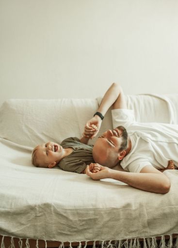 Funny, father and son on a couch, humor and family with...