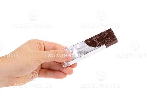 Hand holds bar of chocolate in foil.