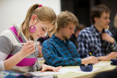 pretty, female college student sitting in a classroom...