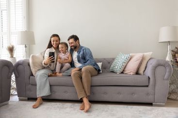 Happy family couple and little daughter child sitting on...